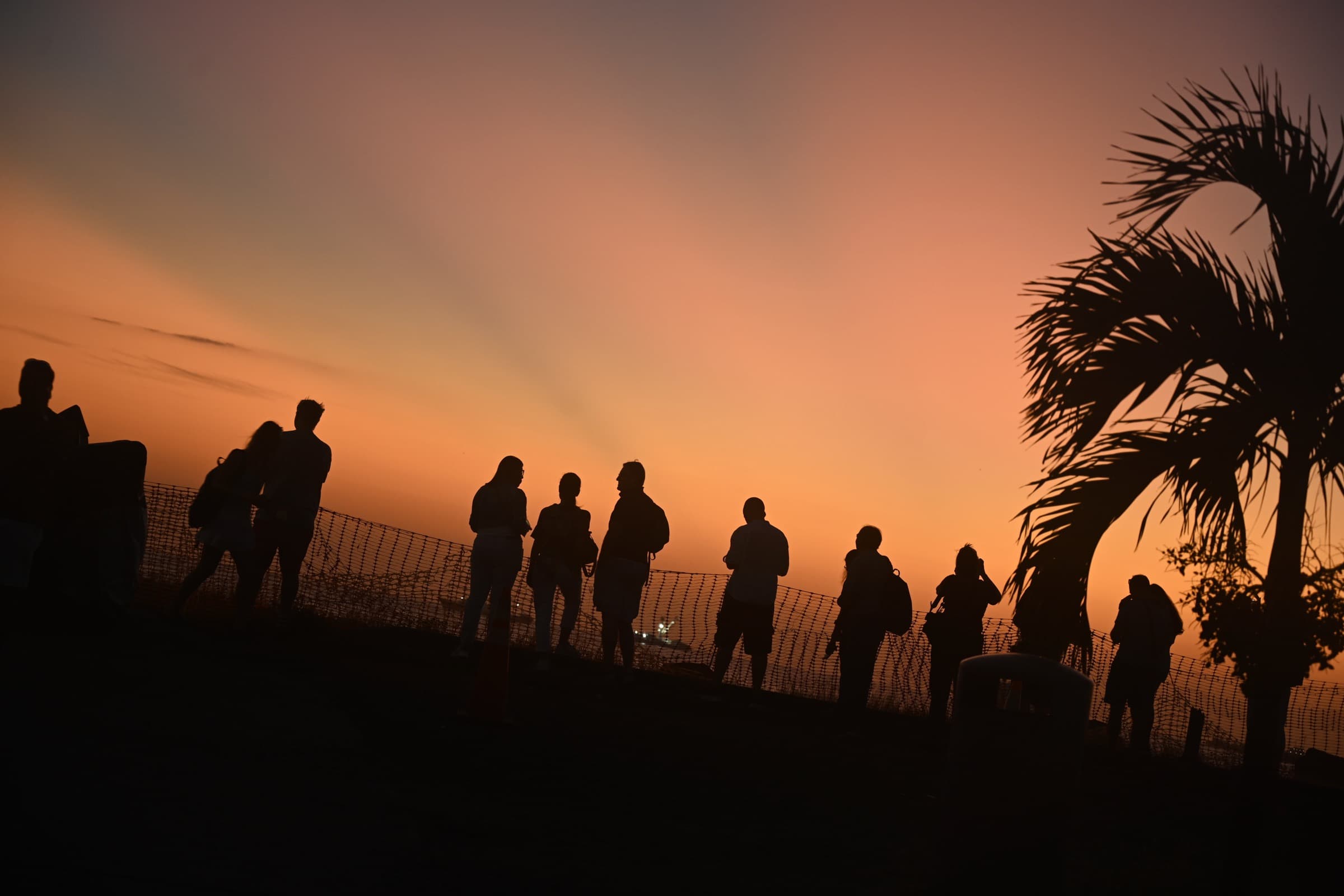 Silhouetted visitors against an orange sunset during a Panama stopover.