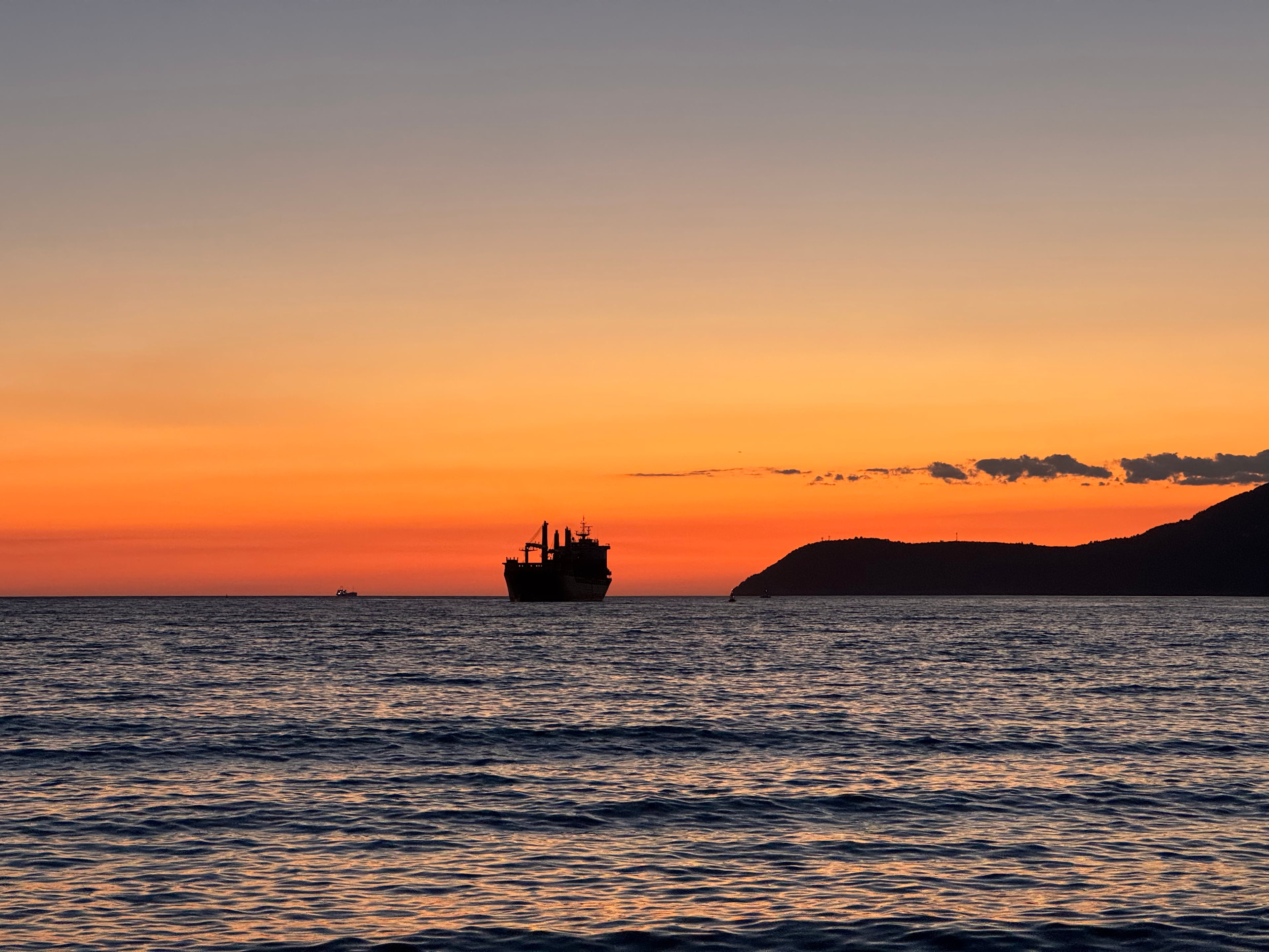 A cargo ship at sunset off the waterfront in Bar, Montenegro.