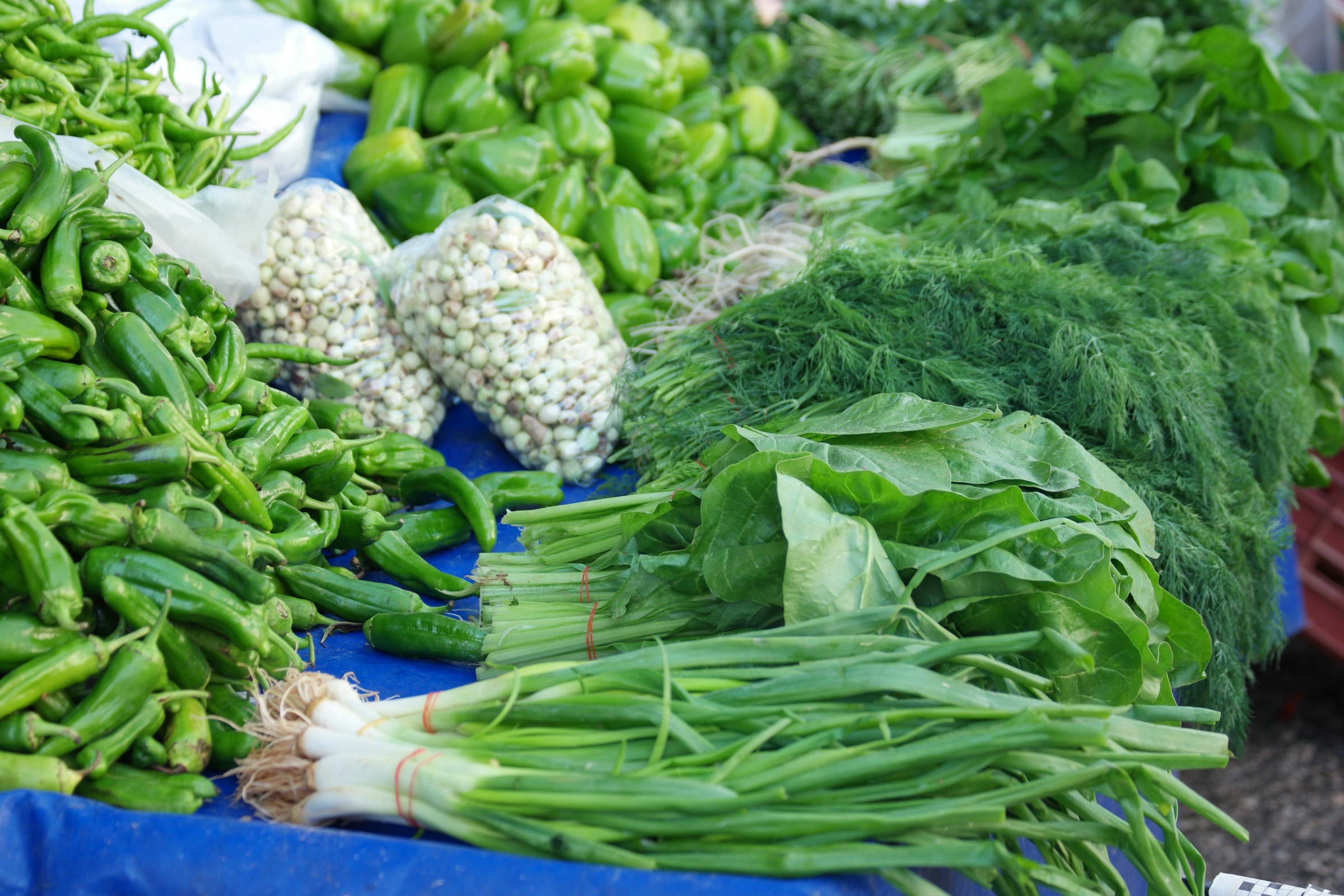 Fresh produce displayed at an outdoor green market.
