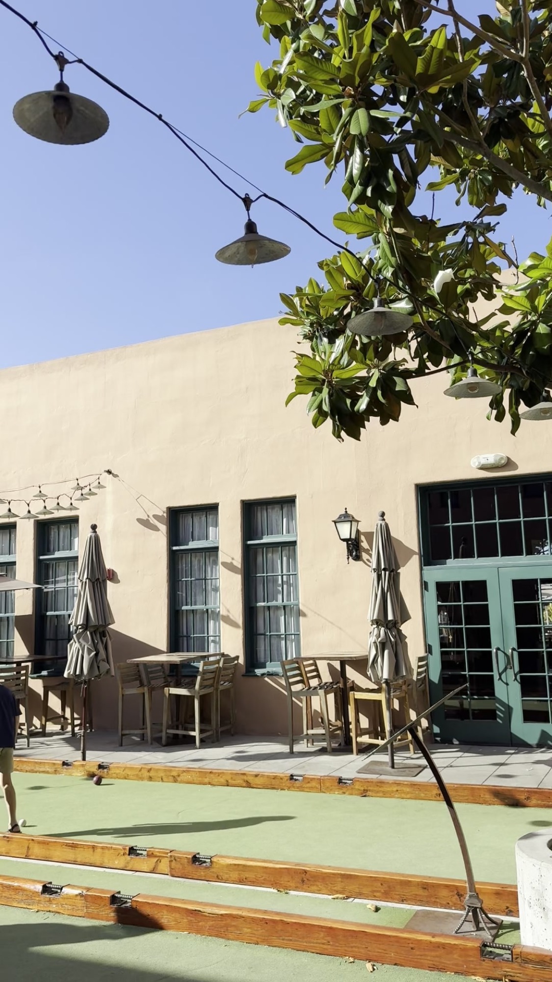 Exterior courtyard with bocce court and bell pendant.